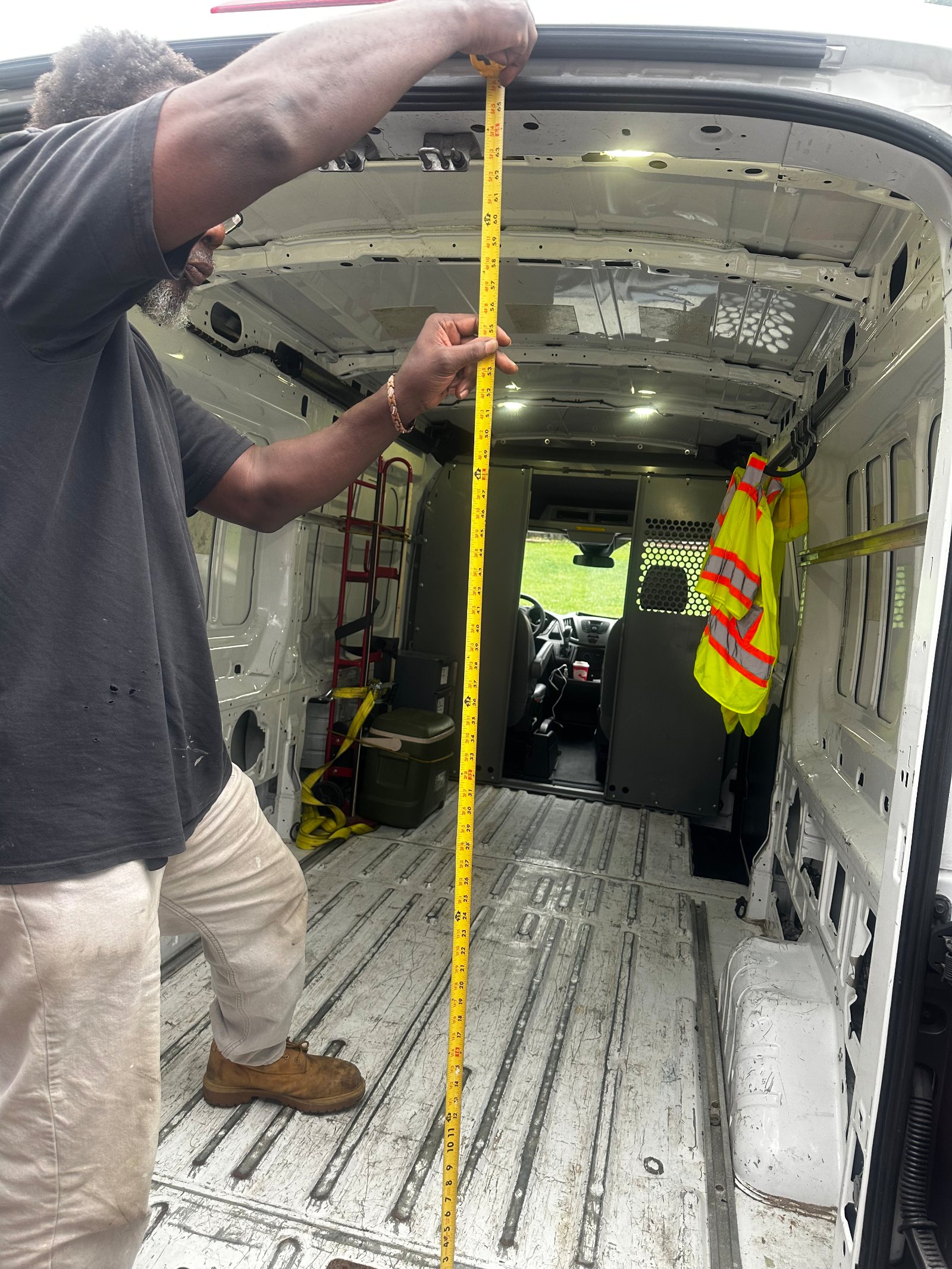 The client's own frame of the owner-operator standing at the open rear doors of the empty, swept bay with a yellow tape